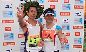 伴走者も一緒に表彰台に上がっている写真